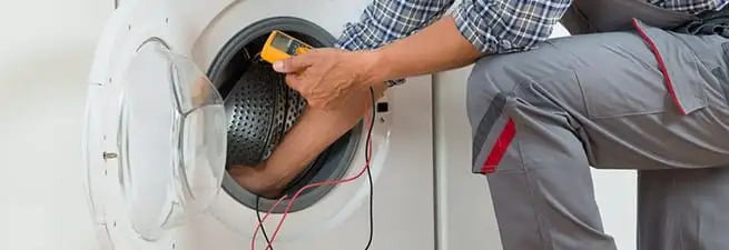 Dryer repair technician inspecting and repairing a clothes dryer in Stockton, CA