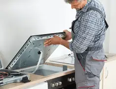 Appliance repair technician installing a built-in cooktop in Stockton, CA