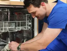 Dishwasher repair technician inspecting and servicing an open dishwasher in Stockton, CA