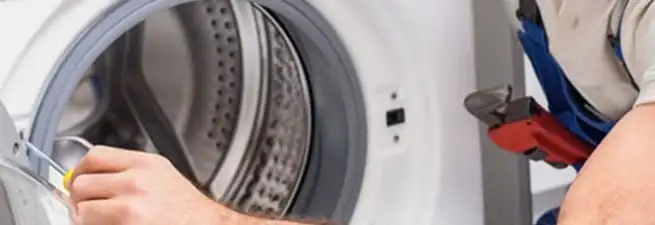Appliance technician repairing a clothes dryer drum and internal parts in Stockton, CA