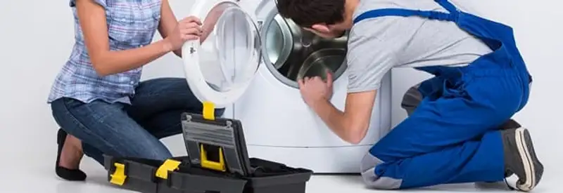 Washer repair technician inspecting a front-load washing machine with tools in Stockton, CA