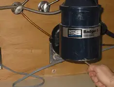 Garbage disposal repair technician tightening the mounting ring under a sink in Stockton, CA