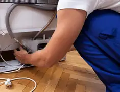 Appliance repair technician fixing refrigerator water line and connections in Stockton, CA