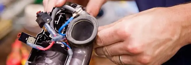 Vacuum repair technician reconnecting wiring and components in Stockton, CA