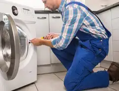 Washing machine repair technician servicing a front-load washer in Stockton, CA