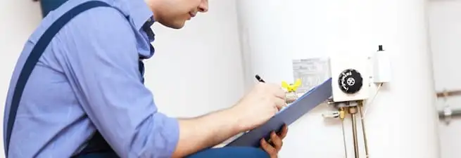 Water heater repair technician inspecting the unit and recording service notes in Stockton, CA