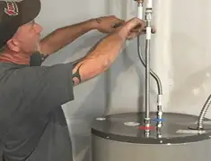 Water heater repair technician tightening supply line connections in Stockton, CA