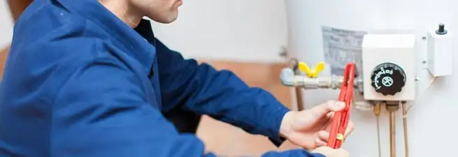 Water heater repair technician adjusting the temperature control and gas valve in Stockton, CA